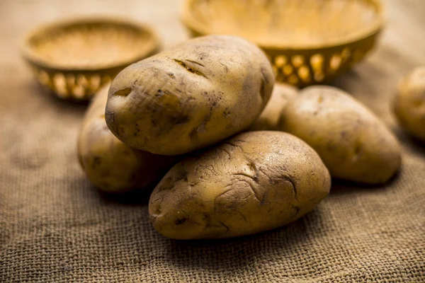 close-up of potatoes near hampers on jute bag surface