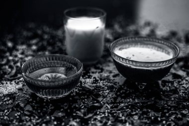 neem yaprakları ile gözlük yapıştırın ve siyah ahşap yüzeyüzerinde bal ile süt hazırlık anti-aging faydaları hint leylak yüz maskesi  