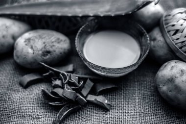 patates suyu iyi çiğ patates ve aloe vera jüt çanta yüzeyinde yaprakları boyunca cam kase içinde aloe vera jel ile karışık, kepek ve kafa derisi temizliği için ev yapımı klima ve şampuan kavramı 