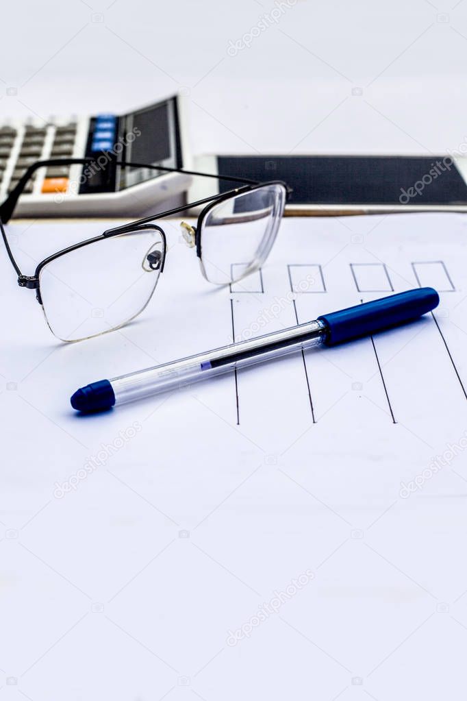 smartphone and eyeglasses with document and pen with calculator on workplace of finance consultant 