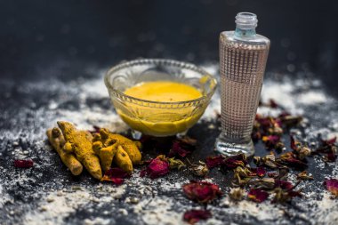 deri pH korumak için gram un yüz maskesi yapmak için masada cam kase içinde zerdeçal ve gül suyu ile karışık nohut unu