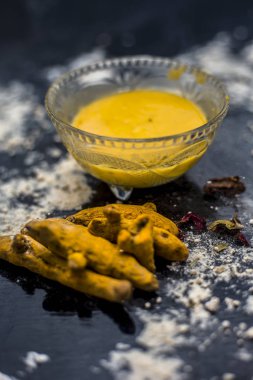 deri pH korumak için gram un yüz maskesi yapmak için masada cam kase içinde zerdeçal ve gül suyu ile karışık nohut unu