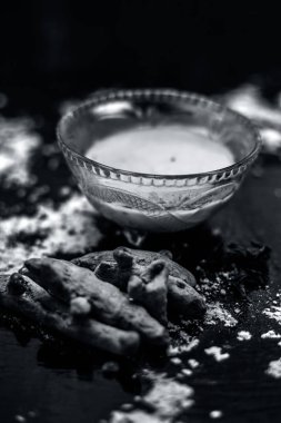 deri pH korumak için gram un yüz maskesi yapmak için masada cam kase içinde zerdeçal ve gül suyu ile karışık nohut unu