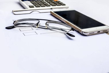 Finans Danışmanı işyerinde belge ve hesap makinesi ile akıllı telefon ve gözlükler 