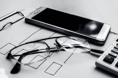 Finans Danışmanı işyerinde belge ve hesap makinesi ile akıllı telefon ve gözlükler 