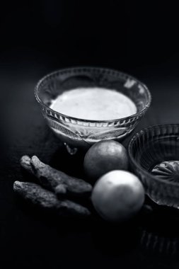 Limon suyu Yüz maskesi, bal, ve bazı ham zerdeçal ile birlikte iyi akne eğilimli cilt ve lekeler için ahşap yüzeyüzerinde tüm ham maddeler ile birlikte cam bir kase karışık.