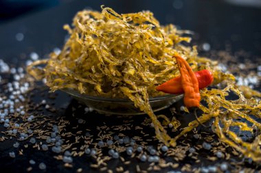 Ahşap yüzeyde şeffaf cam plaka içinde patates ve sago topu chakli ve çiğ kurutulmuş Sabudana ni chakili ünlü Hint ve Gujarati snack çanak 