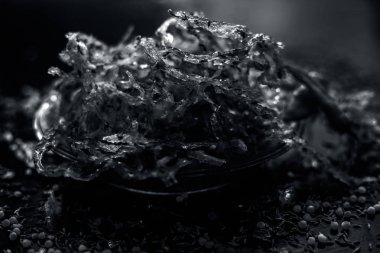 Ahşap yüzeyde şeffaf cam plaka içinde patates ve sago topu chakli ve çiğ kurutulmuş Sabudana ni chakili ünlü Hint ve Gujarati snack çanak 