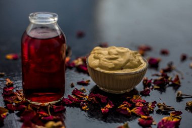 Ahşap yüzeyde yağlı cildin tedavisi için cam gül suyu ile kase Multani mitti oluşan ubtan yüz maskesi 