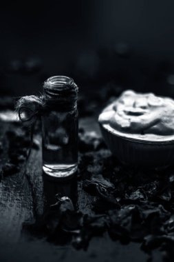 Ahşap yüzeyde yağlı cildin tedavisi için cam gül suyu ile kase Multani mitti oluşan ubtan yüz maskesi 