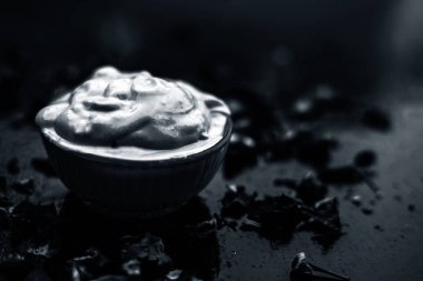 Ahşap yüzeyde yağlı cildin tedavisi için gül yaprakları ile kasede Multani mitti oluşan ubtan yüz maskesi 