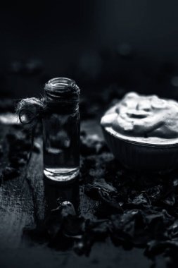 Ahşap yüzeyde yağlı cildin tedavisi için cam gül suyu ile kase Multani mitti oluşan ubtan yüz maskesi 