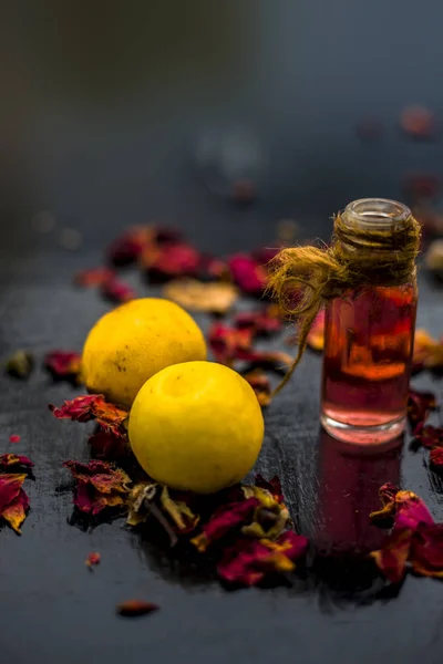 ingredients for DIY face mask of  lemons with rose water on wooden surface