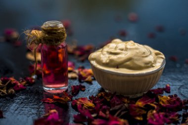 Ahşap yüzeyde yağlı cildin tedavisi için cam gül suyu ile kase Multani mitti oluşan ubtan yüz maskesi 