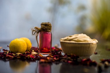 ahşap yüzeyde gül suyu ile Multani mitti ve limon DIY yüz maskesi için malzemeler