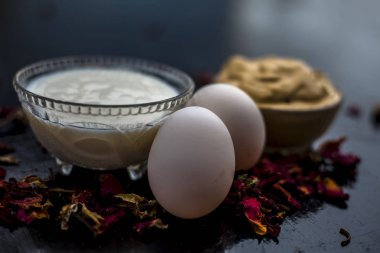 hatta cilt çare için siyah ahşap yüzeyüzerinde yumurta ile multani mitti ve yoğurt Diy yüz maskesi ile kase 