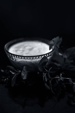 yoğurt oluşan koyu yamalar ve ahşap yüzey üzerinde yaprakları ile kase de tedavi için hazırlık ev yapımı Diy yüz maskesi için malzemeler 