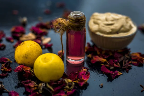 ahşap yüzeyde gül suyu ile Multani mitti ve limon DIY yüz maskesi için malzemeler