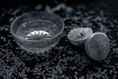 ahşap yüzeyüzerinde ham limon ve çemen tohumu ile cam kase de limon suyu ile karıştırılan çemen tohumu tozu oluşan kepek için doğal saç kremi 