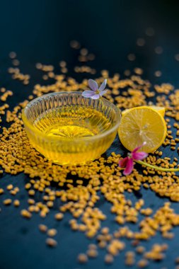 ahşap yüzeyüzerinde ham limon ve çemen tohumu ile cam kase de limon suyu ile karıştırılan çemen tohumu tozu oluşan kepek için doğal saç kremi 