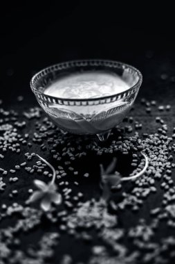 yüzeyde çiğ lor ve çemen tohumu ile birlikte lor ile iyice karıştırılmış çemen tohumu tozu oluşan cam kase ahşap yüzeyde kepek için doğal yöntem
