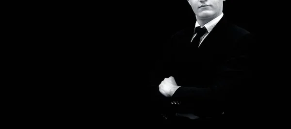 一个商人穿着深蓝色夹克和黑色领带的黑色隔离的黑色半长镜头 用折叠的手构成成功 — 图库照片