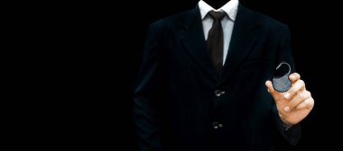 Elinde asma kilit olan siyah zeminüzerine izole edilmiş siyah kravatlı koyu renkli bir takım elbise giyen işadamı, siber ve finansal güvenliği gösteriyor..