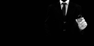 Elinde asma kilit olan siyah zeminüzerine izole edilmiş siyah kravatlı koyu renkli bir takım elbise giyen işadamı, siber ve finansal güvenliği gösteriyor..