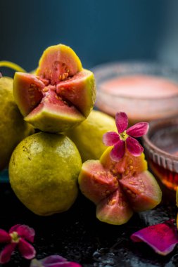 Guava hamuru, bal ve bazı limon suyu oluşan guava yüz maskesi ile akne ve izleri tedavi etmek için en kolay yöntem. Cam bir kapta ahşap yüzey üzerinde malzemelerle.