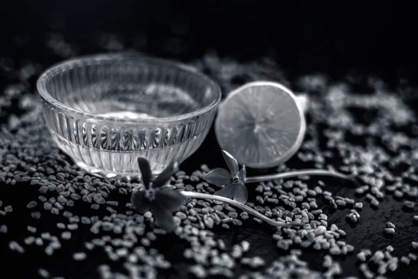 Limon suyu ile karıştırılmış çemen tohumu tozundan oluşan cam bir kapta ahşap yüzeyde kepek için ünlü doğal yöntem. Yüzeyinde mevcut çiğ limon ve çemen tohumu ile.