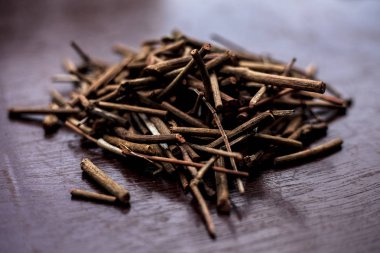 Eski Ayurveda'dan elde edilen çeşitli sağlık yararları ile manjistha/manzistha/Rubia cordifolia/madder vb. olarak da bilinen kahverengi renkli ahşap yüzeyde Hint madderwort veya madder kökü Demeti.