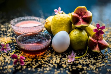 Bal, guava hamuru, yumurta sarısı ve bazı yulaf ezmesi oluşan ahşap bir yüzey üzerinde yüz maskesi yardımı ile kuru cilt tedavisi, iyi ham maddeler ile birlikte bir cam kase karışık.