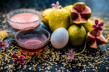 Bal, guava hamuru, yumurta sarısı ve bazı yulaf ezmesi oluşan ahşap bir yüzey üzerinde yüz maskesi yardımı ile kuru cilt tedavisi, iyi ham maddeler ile birlikte bir cam kase karışık.