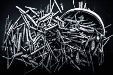 Manjistha/manzistha/Rubia cordifolia/madder vb. olarak da bilinen siyah ahşap yüzeyde kahverengi renkli bir sepetiçinde Hint madderwort veya madder kök Demet.