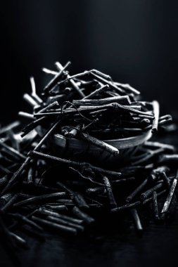 Manjistha/manzistha/Rubia cordifolia/madder vb. olarak da bilinen siyah ahşap yüzeyde kahverengi renkli bir sepetiçinde Hint madderwort veya madder kök Demet.