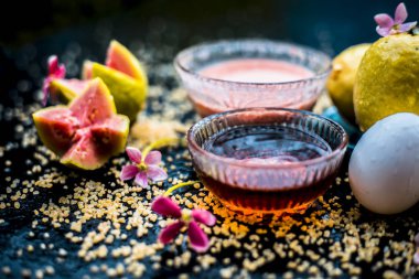 Canlı renklerle ahşap bir yüzey üzerinde kuru ciltler için Guava yüz maskesi yani, guava hamuru, yumurta sarısı, yulaf ezmesi, ve bazı ham organik bal iyi çiğ olanlar ile birlikte bir cam kase karışık.