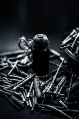 Manjistha/manzistha/Rubia cordifolia/madder vb. olarak da bilinen siyah ahşap yüzeyde kahverengi renkli bir sepetiçinde Hint madderwort veya madder kök Demet.