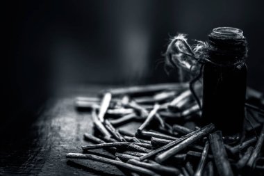 Manjistha/manzistha/Rubia cordifolia/madder vb. olarak da bilinen siyah ahşap yüzeyde kahverengi renkli bir sepetiçinde Hint madderwort veya madder kök Demet.