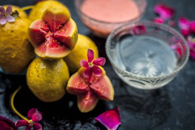 Bazı guava hamuru iyi su ile karışık oluşan bulanık bir arka plan ile ahşap bir yüzey üzerinde parlayan cilt için Guava yüz maskesi.