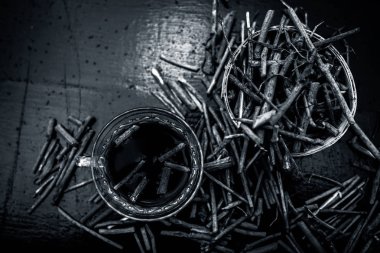 Bir bardak çayı ile manjistha / manzistha / Rubia cordifolia / madder vb olarak da bilinen siyah ahşap yüzeyüzerinde kahverengi renkli sepet hint madderwort veya madder kök Demet.