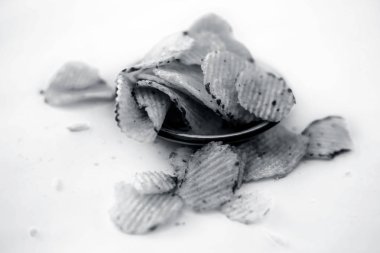 Organik işlenmiş patates cipsi beyaz izole bir cam tabakta.