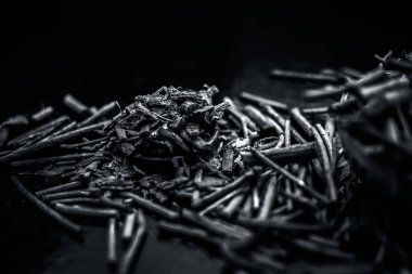 Küçük kahverengi bir plaka içinde toz ile de manjistha / manzistha / Rubia cordifolia / madder vb olarak bilinen siyah ahşap yüzeyüzerinde kahverengi renkli sepet hint madderwort veya madder kök Demet.