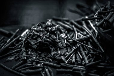 Küçük kahverengi bir plaka içinde toz ile de manjistha / manzistha / Rubia cordifolia / madder vb olarak bilinen siyah ahşap yüzeyüzerinde kahverengi renkli sepet hint madderwort veya madder kök Demet.