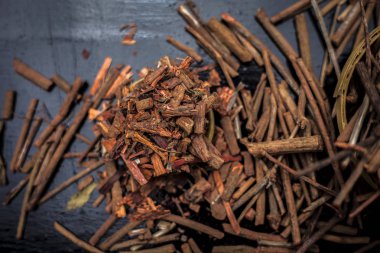 Küçük kahverengi bir plaka içinde toz ile de manjistha / manzistha / Rubia cordifolia / madder vb olarak bilinen siyah ahşap yüzeyüzerinde kahverengi renkli sepet hint madderwort veya madder kök Demet.
