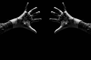 Erkek elleri siyah arka planda boyayla kaplıdır.