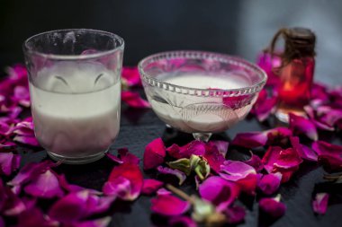 Cam kaplarda gül suyuyla karıştırılmış taze süt yapraklarla çevrili.