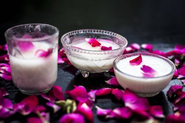 Cam kaplarda gül suyuyla karıştırılmış taze süt yapraklarla çevrili.