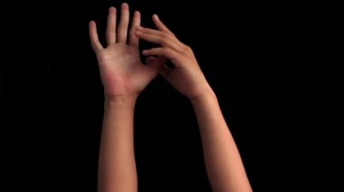 İki insan eli geliyor ve bir diğerini kaşındırıyor. Siyah üzerine izole edilmiş..