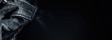 Siyah renkli kot pantolon kumaşı ile siyah bulanık arka plan.
