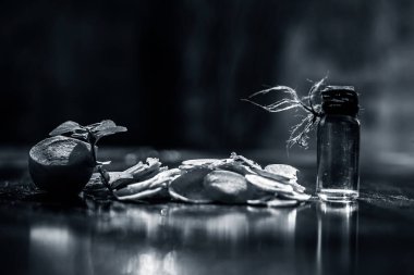 Siyah masa yüzeyinde kesilmiş taze havuçlar, bulanık arka plan ve küçük şeffaf cam bir şişede çıkarılmış gerekli yağlar. Yatay çekim.